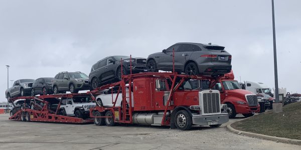 Car hauling truck delivering vehicles to dealerships